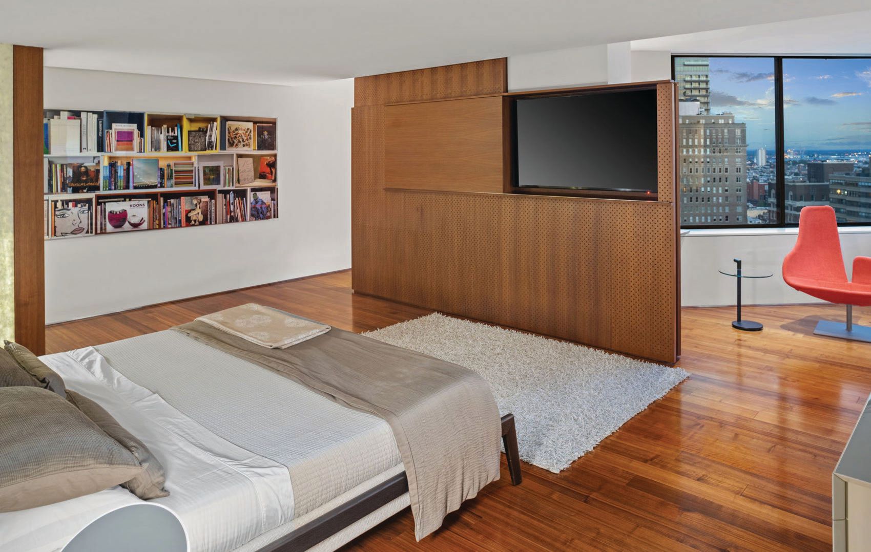 A perforated wood panel in the bedroom tucks a TV within PHOTO BY OM MEDIA