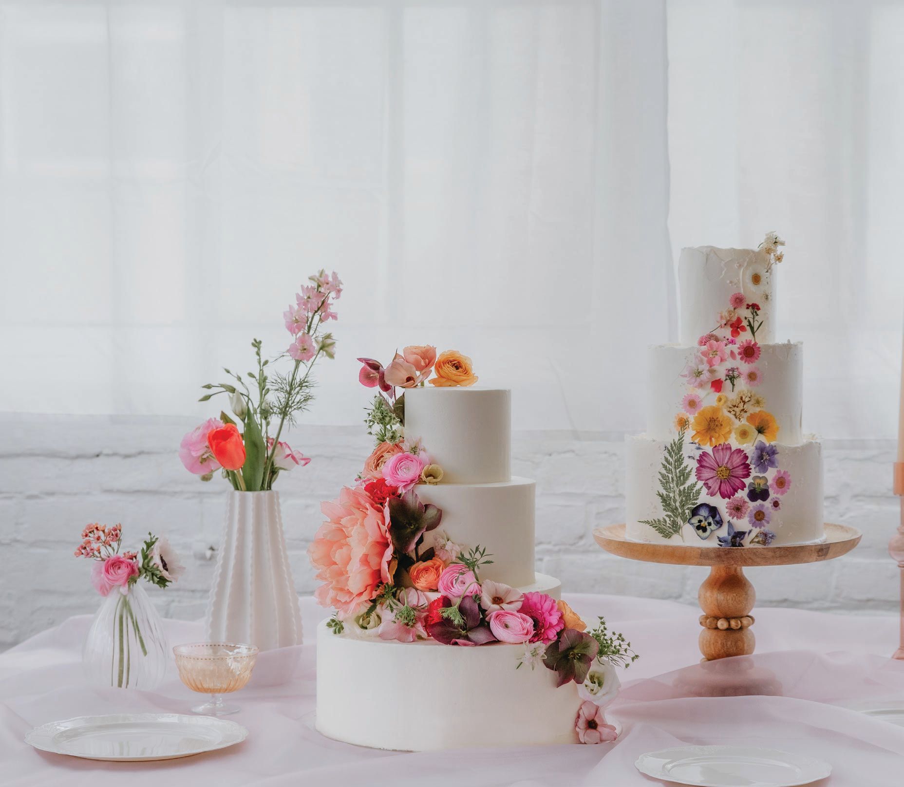 New June is known for its incredible floral designs such as these tiered cakes adorned with sweeping fresh spring peonies, wild flowers, poppies, ranunculus and vibrant pressed florals. PHOTO BY KIERSTEN ALDRIDGE PHOTOGRAPHY