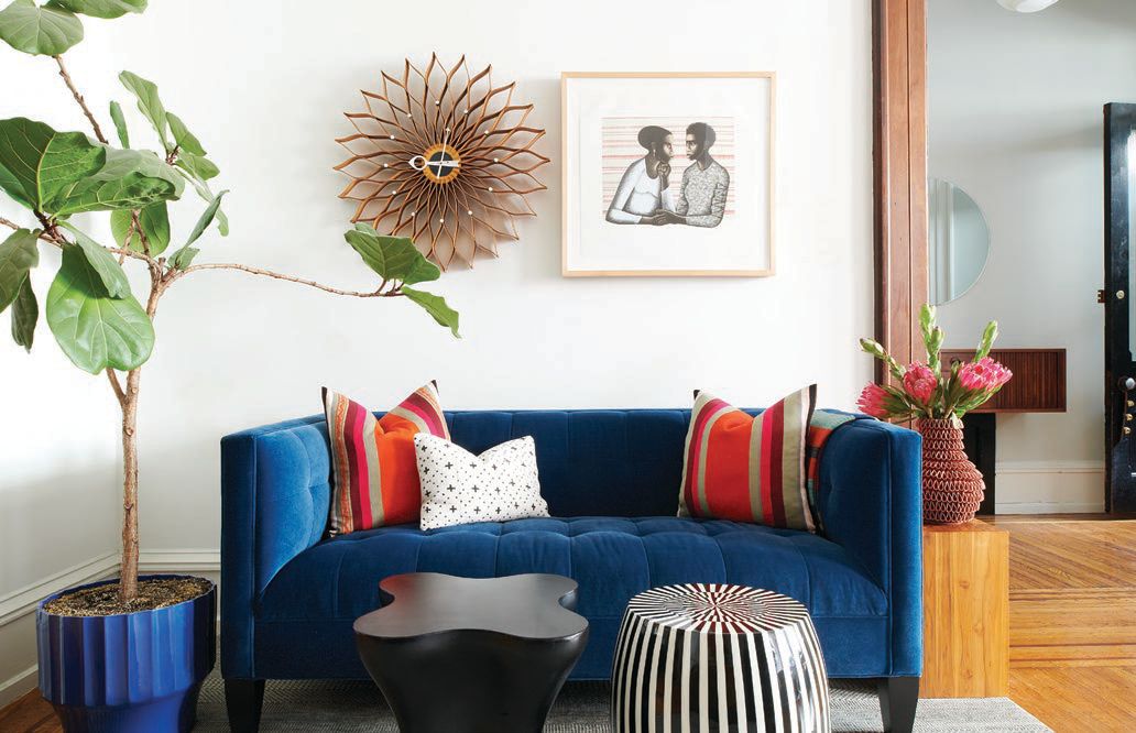 A blue, tufted sofa occupies the corner of a communal space PHOTO COURTESY OF REBECCA MCALPIN