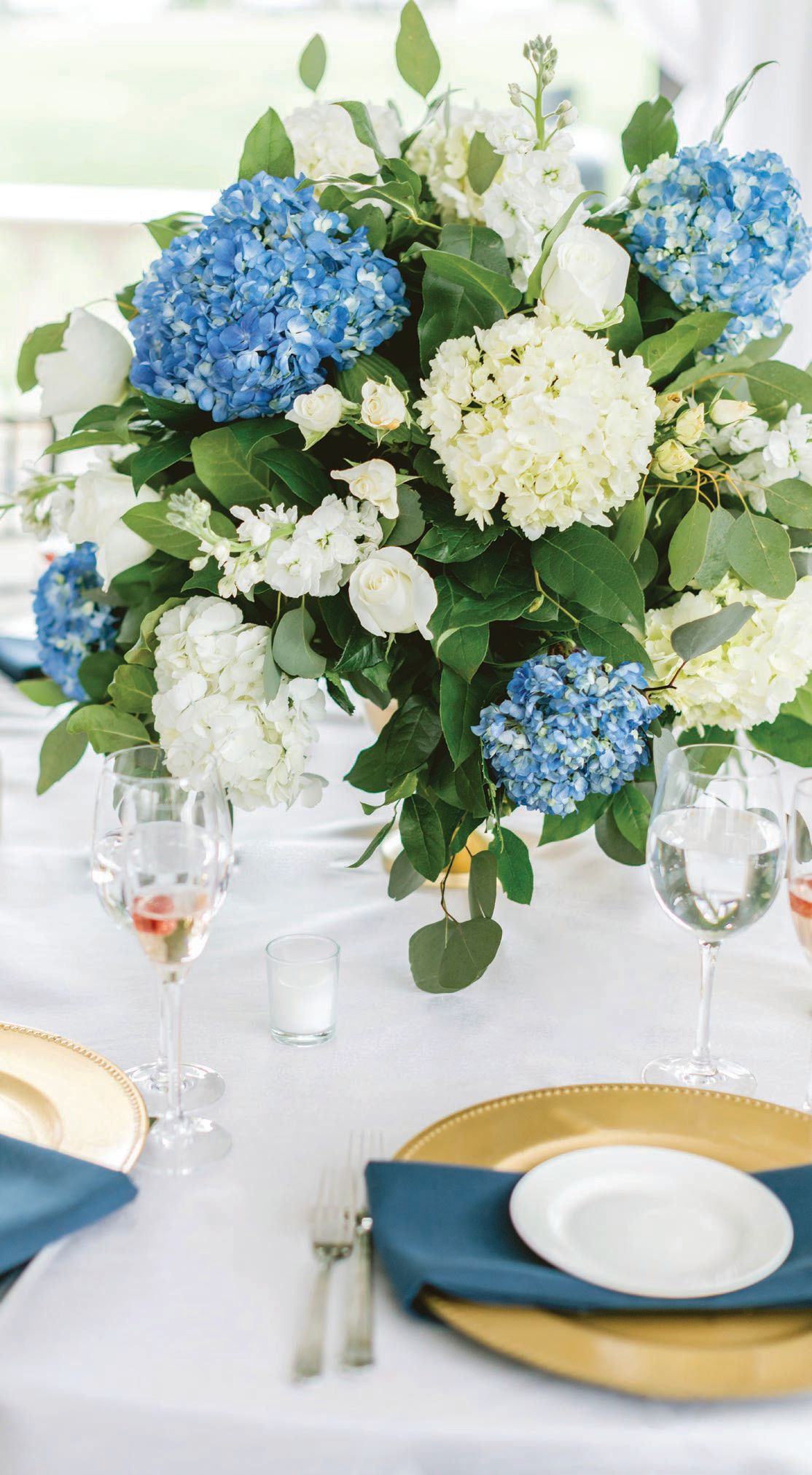 Blue hydrangea adds a pop of color without stealing the spotlight in this centerpiece by Beautiful Blooms. PHOTO BY EMILY WREN PHOTOGRAPHY