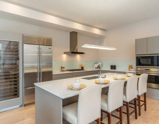 With sunshine pouring through floor-to- ceiling windows, the kitchen uses soft , recessed lighting. PHOTO BY WEFILMPHILLY